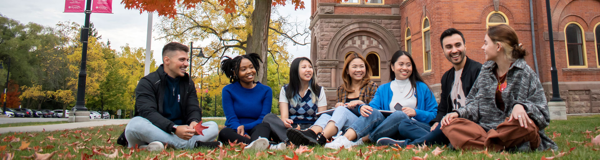 A group of Humber international students sitting outside at Lakeshore campus